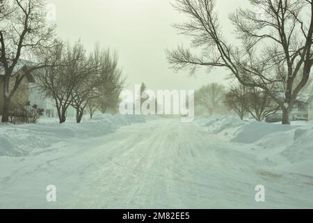 In den Straßen von Bismarck, North Dakota, wird Schnee von schweren Schneefällen im Dezember angehäuft, was zu rutschigen Fahrbedingungen führt. Stockfoto
