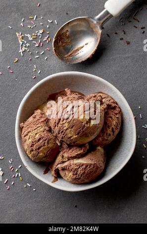Schale mit Schokolade und Karamelleis auf grauem Hintergrund, Draufsicht Stockfoto