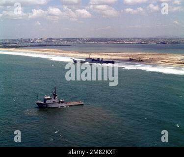 Ein Luftbögen-Blick auf den Flottenschlepper USNS NARRAGANSETT (T-ATF 167), der sich auf das Panzerlandeschiff USS BARBOUR COUNTY (LST 1195) vorbereitet, nachdem er auf Grund auf Silver Strand gelaufen ist. Basis: San Diego Staat: Kalifornien (CA) Land: Vereinigte Staaten von Amerika (USA) Stockfoto
