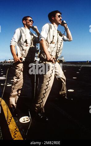 Ein Landesignal-Offizier (LSO) spricht vom Cockpit des Flugzeugträgers USS MIDWAY (CV 41) aus mit einem ankommenden Piloten, da seine Unterstützung dabei hilft, den Anflug zu verfolgen. Land: Unbekannt Stockfoto