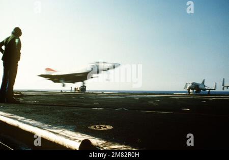 Ein Bediener von Fanggeräten beobachtet, wie ein F-4S Phantom II-Flugzeug an Bord des Flugzeugträgers USS MIDWAY (CV 41) landet. Rechte Vorderansicht des Phantoms. Land: Unbekannt Stockfoto