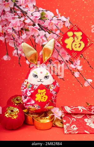 Tradition Chinesische Stoffpuppe Hase, 2023 ist Jahr des Hasen, Chinesische goldene Figuren Übersetzung: Gute Gesundheit für das Jahr des Hasen, Wort auf Gold Stockfoto