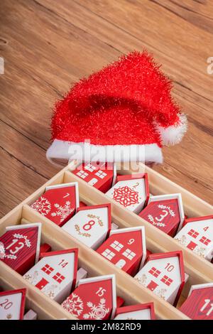 Handgefertigter Kalender aus Holz in Form eines Hauses mit weihnachtshut Stockfoto