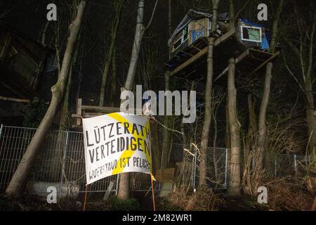 Erkelenz, Deutschland. 11. Januar 2023. Ein Banner mit der Inschrift "Defense Lützerath" hängt vor einem Baumhaus. Das Energieunternehmen RWE will die unter Lützerath liegende Kohle ausgraben - dafür soll das Weiler auf dem Territorium der Stadt Erkelenz am Braunkohlebergwerk Garzweiler II abgerissen werden. Das Energieunternehmen RWE will die Kohle unter Lützerath ausheben - im Gegenzug soll das Weiler auf dem Gebiet der Stadt Erkelenz im Braunkohlebergwerk Garzweiler II abgerissen werden. Kredit: Thomas Banneyer/dpa/Alamy Live News Stockfoto