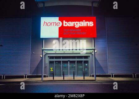 Home-Schnäppchen-Shop-Schild über dem Haupteingang bei Nacht mit No People Clyde Retail Park, Livingston Street, Clydebank Stockfoto