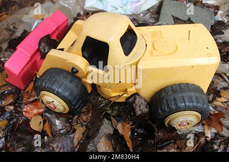 Gelber Kunststoff-Bulldozer auf nassem Untergrund Stockfoto