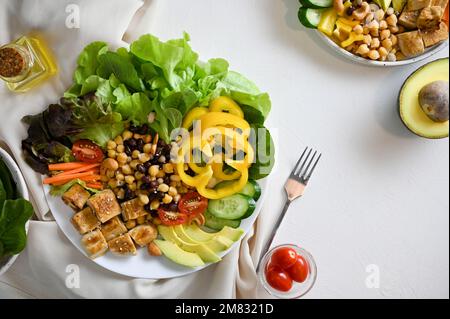 Gesunde Ernährung, vegane Lebensweise, pflanzliche Mahlzeit, Buddha Salatschüssel. Gegrillter Tofu mit Kichererbsen, Bohnen und Salatgemüse gemischt. Draufsicht Stockfoto