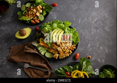 Pflanzliche Speisen, vegane Speisekarte, Buddha-Schüssel, gegrillter Tofu mit Kichererbse, Nüssen und gesundem grünen Salatgemüse. Stockfoto