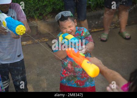 Ein unidentifizierter kleiner Junge, der Wasserspray mit einer Plastikpistole spielt. Nehmen Sie am Songkran Festival Teil, dem traditionellen Neujahrstag vom 13. Bis 15. April. Stockfoto