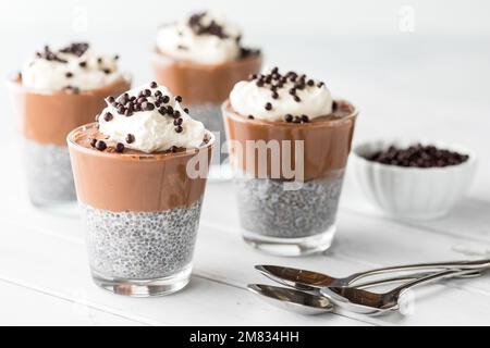 Schokoladen-Mousse-Chia-Pudding-Snacks garniert mit Schokoladen-Quinoa-Puffs. Stockfoto