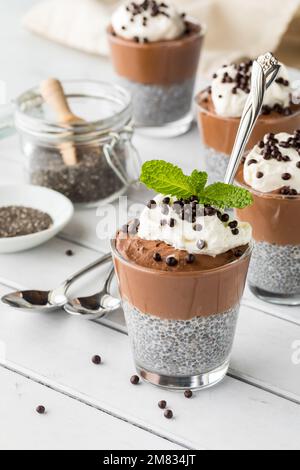 Schokoladen-Chia-Pudding-Desserts, garniert mit Schokoladen-Quinoa-Puffs. Stockfoto