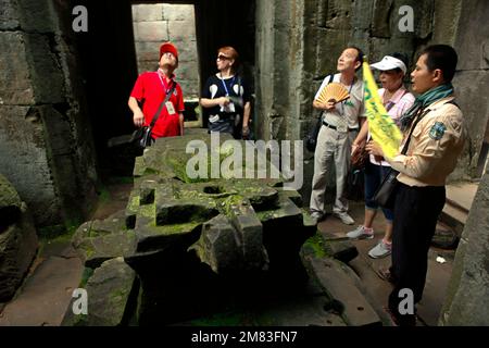 Eine Gruppe von Touristen wird von einem zertifizierten Reiseleiter auf diesem Archivfoto vor einem Artefakt in einem Kammerschrein am Prasat Preah Khan (Preah Khan Tempel) in Siem Reap, Kambodscha, erläutert. Im vergangenen Jahr (2022) begrüßte Angkor 287.454 internationale Touristen und verdiente 11,5 Millionen US-Dollar aus dem Ticketverkauf, wie das staatseigene Unternehmen Angkor Enterprise in einer von Xinhua am 5. Januar 2023 zitierten Pressemitteilung mitteilte. Stockfoto