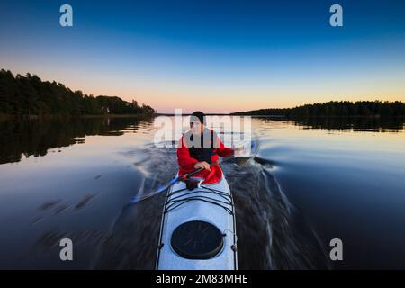 Outdoor Fotograf Øyvind Martinsen in seinem Kajak auf dem See Vansjø, Østfold, Norwegen. Vansjø ist ein Teil des Wassers, das System namens Morsavassdraget. Stockfoto