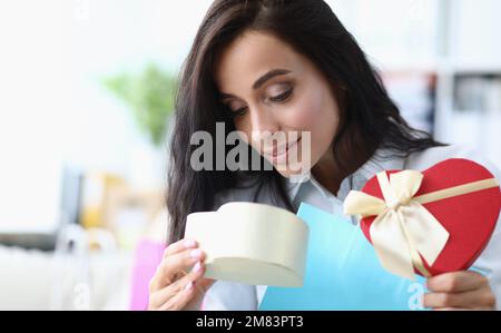 Schöne Frau öffnet Geschenkbox. Ein Geschenk von einem geliebten Menschen Stockfoto