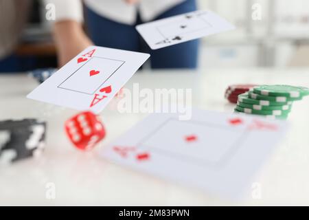 Die Hand wirft Karten mit Assen und Würfeln Stockfoto