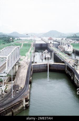 Schlepper unterstützen das stillgelegte nuklearbetriebene Angriffs-U-Boot NAUTILUS (SSN-571) durch die Miraflores-Schleusen. Das NAUTILUS ist auf dem Weg zu seinem ursprünglichen Heimathafen an der Naval Submarine Base, New London, Conn., wo es als Gedenkstätte in der Submarine Force Library and Museum bleibt. Basis: Panamakanal: Panama (PAN) Stockfoto