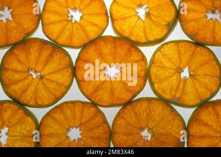 Tangerine Schichten bei Hintergrundbeleuchtung. Hintergrund des Zitrusmusters. Stockfoto