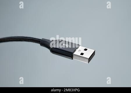 Nahaufnahme des USB-Kabelanschlusses auf grauem Hintergrund Stockfoto