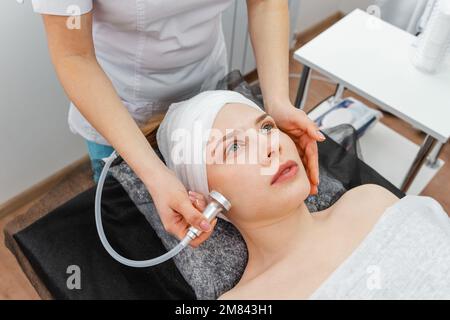 Weibliche Ärztin für Kosmetik, die eine Rollermassage mit Apparaten durchführt Stockfoto