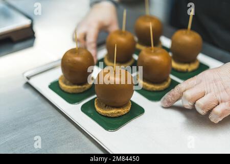 Nahaufnahme von Äpfeln, die mit Karamell bedeckt sind und in ihnen hängen, köstliches Dessert. Hochwertiges Foto Stockfoto