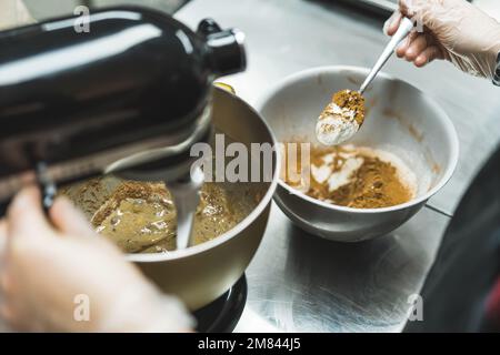 bäcker bereitet Teig zu und mischt Zutaten, Backkonzept. Hochwertiges Foto Stockfoto