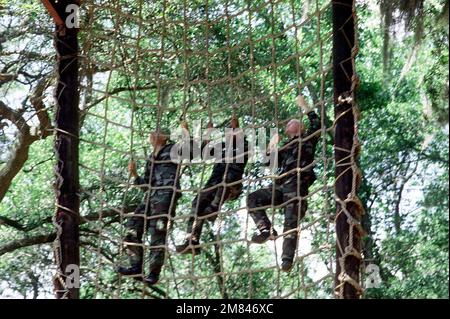 Rekruten klettern während der Grundausbildung im Rekrutierungslager des Marine Corps auf ein Frachtnetz. Basis: USMC Recruit Depot, Parris Island Bundesstaat: South Carolina (SC) Land: Vereinigte Staaten von Amerika (USA) Stockfoto