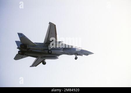 Unteransicht eines US Navy F-14A Tomcat-Flugzeugs vom Fighter Squadron Seventy-Four (VF-74), das das Flugzeug Carrier USS SARATOGA (nicht abgebildet) überquert, nachdem es während des Flugbetriebs vor der Küste Floridas abgewindet hat. Das Flugzeug hat sowohl das Fahrwerk als auch den Haken in der unteren Position zur Vorbereitung der Landung. Land: Atlantik (AOC) Stockfoto