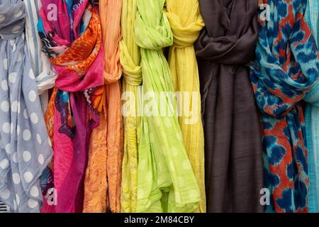 Viele farbenfrohe Kleidungszubehör hängen draußen Stockfoto