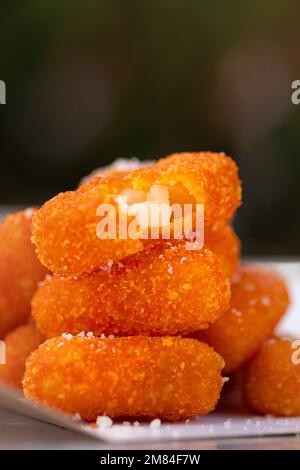 Essenslieferung, Käsestifte zum Mitnehmen, Papierbehälter mit panierten Mozzarella-Käsestiften und Sauce. Stockfoto