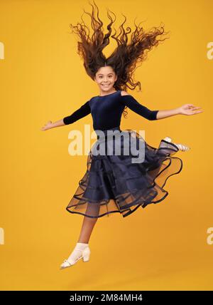 In voller Länge überglücklich Teenager Kind Mädchen 12 13 14 Jahre springen alt isoliert auf gelbem Hintergrund Studio. Witziger Sprung. Kind im Sommer Bewegungskleid. Stockfoto