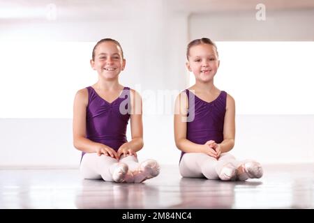 Ballerinas in der Herstellung. Fröhliche junge Ballerinas, die in einem Ballettstudio sitzen. Stockfoto