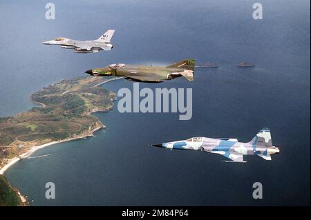 Air-to-Air-Ansicht von links: Ein Flugzeug der Royal Thai Air Force F-5E Tiger II, ein Flugzeug der F-4E Phantom II aus dem taktischen Kampffluggeschwader 497. und ein Flugzeug der F-16 Fighting Falcon aus dem taktischen Kampfflugflügel 432., das während der Übung Cope Thunder 86-3 in Formation fliegt. Während der Übung werden mehr als 60 Flugzeuge aus den USA und dem Fernen Osten in täglichen Kampfszenarien, Hundeschlittenschlägen und Bombenanschlägen gegeneinander antreten. Betreff Betrieb/Serie: COPE THUNDER '86-3 Land: Philippinen (PHL) Stockfoto