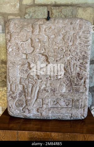 Vorhispanische Steinschnitzerei, die einen Mann, Lapida 8, in seinem Leichensattel zeigt. Museum of Oaxacan Culture, Oaxaca, Mexiko. Er scheint mit ihm zu sprechen Stockfoto