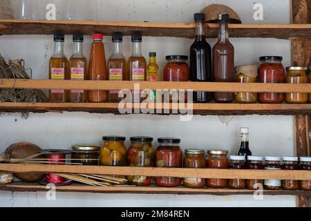 Hausgemachter Kombucha Vinager, Salsa und Obst und Gemüse in Flaschen zum Verkauf auf einem kleinen Straßenmarkt in Oaxaca, Mexiko. Stockfoto