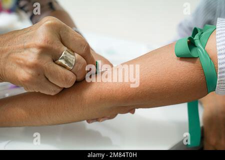 Eine nicht erkennbare Krankenschwester entnimmt einem Patienten Blut. Häusliche Krankenpflege Stockfoto