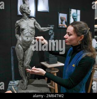 London UK 12. Januar 2023 The Antiques Dealers Fair Limited. DER QEST-Gelehrte Poppy Field, dessen Skulptur der verstorbenen Königin Elizabeth II. Und Prinz Philip in diesem Jahr in der Royal Albert Hall errichtet werden soll, wird mit Lehm skulplieren. Paul Quezada-Neiman/Alamy Live News Stockfoto