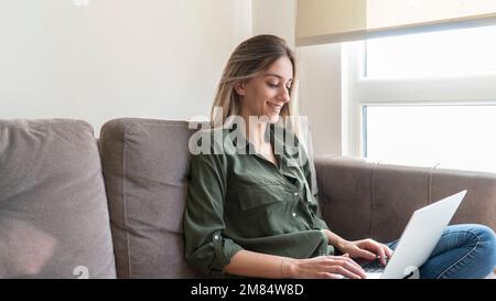 Junge, erfolgreiche Unternehmerin, die online ein Unternehmen gründet. Selbstbewusste Frau und E-Commerce-Konzept. Stockfoto