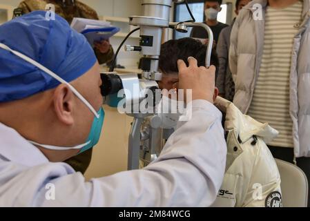 Fuyang, China. 12. Januar 2023. Eine Krankenschwester entnimmt einem jungen Mann Blut für ein paar Gesundheitschecks, bevor er ins Militär eingeliefert wird. Diese jungen Menschen wollen Soldaten werden, aber sie müssen sich strengen physischen und anderen Kontrollen unterziehen, bevor sie Soldaten werden können. Kredit: SOPA Images Limited/Alamy Live News Stockfoto