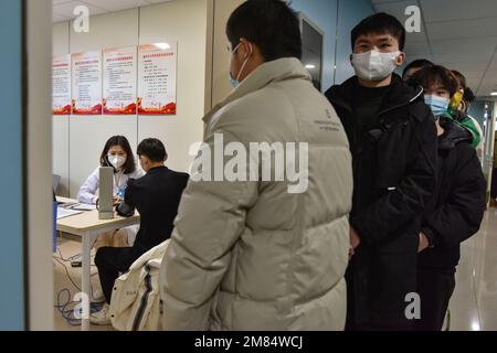 Fuyang, China. 12. Januar 2023. Ein Arzt überprüft den Blutdruck eines jungen Mannes, bevor er als Soldat aufgenommen wird. Diese jungen Menschen wollen Soldaten werden, aber sie müssen sich strengen physischen und anderen Kontrollen unterziehen, bevor sie Soldaten werden können. Kredit: SOPA Images Limited/Alamy Live News Stockfoto