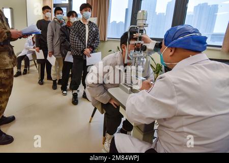 Fuyang, China. 12. Januar 2023. Ein Arzt untersucht die Augen eines jungen Mannes, bevor er ins Militär eingeliefert wird. Diese jungen Menschen wollen Soldaten werden, aber sie müssen sich strengen physischen und anderen Kontrollen unterziehen, bevor sie Soldaten werden können. (Foto: Sheldon Cooper/SOPA Images/Sipa USA) Guthaben: SIPA USA/Alamy Live News Stockfoto