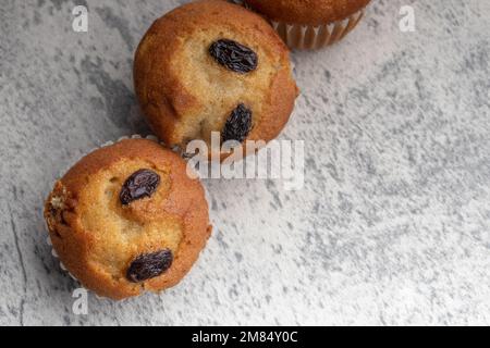 Bananen-Cupcakes mit Rosinen. Kopierbereich auf grauen Hintergrund. Stockfoto