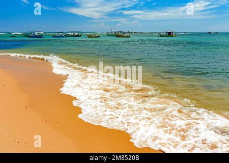 Fischerboote vor Anker im Wasser des berühmten Itapua Beach in Salvador, Bahia Stockfoto