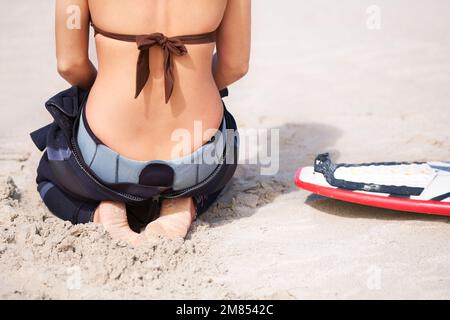 Sie kann es kaum erwarten, das Wasser zu treffen. Eine junge Surferin, die sich an einem heißen Sommertag bereit macht, auszugehen und die Wellen zu genießen. Stockfoto