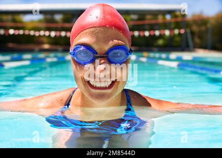 Der Pool ist wie ein zweites Zuhause. Nahaufnahme einer Schwimmerin, die in einem Schwimmbad ins Wasser tritt. Stockfoto
