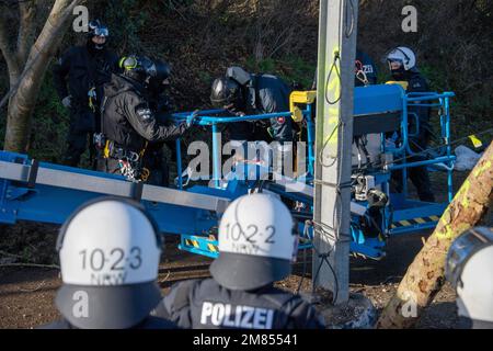 Garzweiler, Deutschland. 11. Januar 2023. Polizeibeamte nehmen einen Aktivisten mit einer Hebebühne aus einem Baum, die Polizei begann heute, das Dorf Luetzerath zu räumen, am 11. Januar 2023, das Dorf Luetzerath an der Westseite des Garzweiler-Braunkohlebergwerks wird im Januar 2023 ausgegraben, Luetzerath, 11. Januar 2023, Kredit: dpa/Alamy Live News Stockfoto