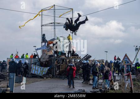 Garzweiler, Deutschland. 11. Januar 2023. Aktivisten haben sich an eine Blockade vor dem Stadteingang geknüpft, die Polizei hat heute, am 11. Januar 2023, mit der Räumung der Stadt Luetzerath begonnen, Kredit: dpa/Alamy Live News Stockfoto