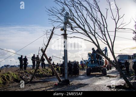 Garzweiler, Deutschland. 11. Januar 2023. Polizeibeamte nehmen einen Aktivisten mit einer Hebebühne aus einem Baum, die Polizei begann heute, das Dorf Luetzerath zu räumen, am 11. Januar 2023, das Dorf Luetzerath an der Westseite des Garzweiler-Braunkohlebergwerks wird im Januar 2023 ausgegraben, Luetzerath, 11. Januar 2023, Kredit: dpa/Alamy Live News Stockfoto