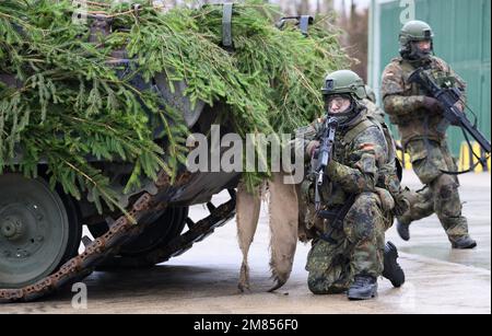 Marienberg, Deutschland. 12. Januar 2023. Gepanzerte Infanteristen präsentieren während des Besuchs des deutschen Verteidigungsministers beim 371. Panzerinfanterie-Bataillon in der Erzgebirgskaserne ein G-36-Sturmgewehr und das Marder-Infanterie-Kampffahrzeug. Neben einer Präsentation der Aufführung der gepanzerten Infanteristen mit ihren Marder-Infanterie-Kampffahrzeugen besteht das Hauptziel des Ministers darin, Gespräche mit den Soldaten zu führen, die für die Schnelle Eingreiftruppe der NATO (VJTF) entsandt wurden. Kredit: Robert Michael/dpa/Alamy Live News Stockfoto