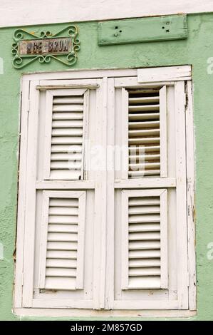 WILLEMSTAD, CURACAO - 22. NOVEMBER 2007: Das Straßenschild Engelbron aus dem 19. Jahrhundert über einem alten weißen Fenster mit geschlossenen Fensterläden in der Naniestraat in t Stockfoto