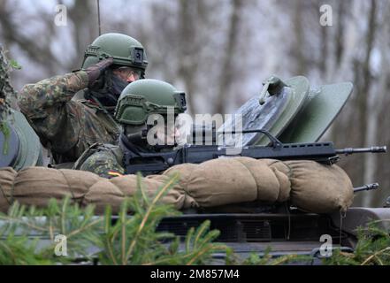 Marienberg, Deutschland. 12. Januar 2023. Ein gepanzerter Infanterie-Mann salutiert aus einem Marder-Infanterie-Kampffahrzeug während seines Besuchs im 371. Panzerinfanterie-Bataillon in der Baracke Erzgebirge. Neben einer Präsentation der Aufführung der gepanzerten Infanteristen mit ihren Marder-Infanterie-Kampffahrzeugen besteht das Hauptziel des Ministers darin, Gespräche mit den Soldaten zu führen, die für die Schnelle Eingreiftruppe der NATO (VJTF) entsandt wurden. Kredit: Robert Michael/dpa/Alamy Live News Stockfoto